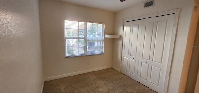 unfurnished bedroom featuring light carpet, a closet, and ceiling fan