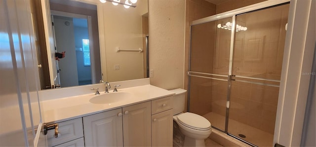 bathroom with vanity, toilet, and a shower with shower door