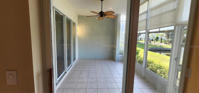 unfurnished sunroom with ceiling fan