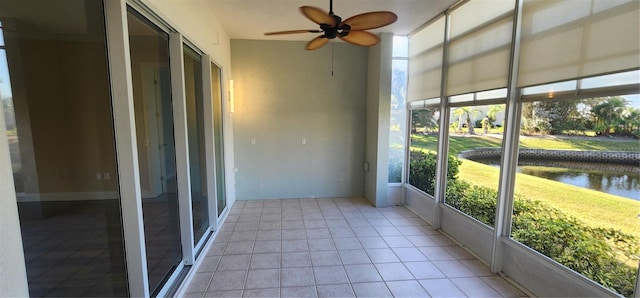 unfurnished sunroom featuring a water view, ceiling fan, and a healthy amount of sunlight