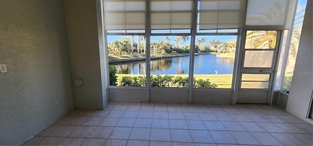 interior space featuring plenty of natural light, a water view, and light tile patterned floors