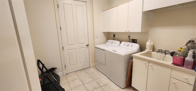 clothes washing area featuring washer and dryer, light tile patterned floors, cabinets, and sink