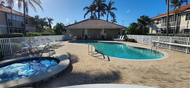 view of swimming pool with a hot tub and a patio area