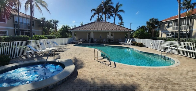 view of swimming pool with a patio area and a hot tub