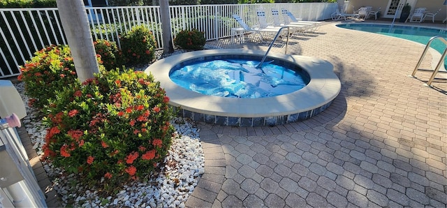 view of swimming pool with a patio area and a hot tub