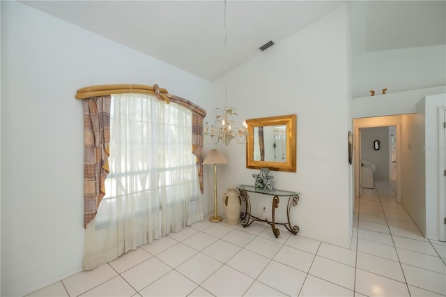 interior space featuring light tile patterned flooring, high vaulted ceiling, and an inviting chandelier