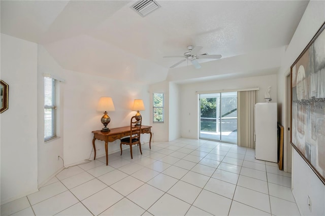 spare room featuring ceiling fan, light tile patterned floors, and vaulted ceiling