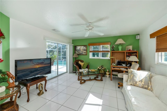 living room with ceiling fan, light tile patterned floors, and a healthy amount of sunlight