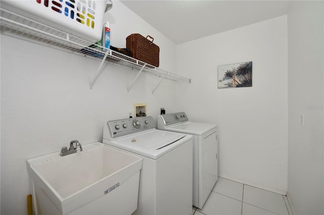 laundry room with light tile patterned floors, sink, and washing machine and clothes dryer