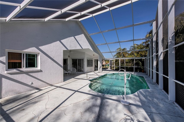 view of swimming pool with glass enclosure and a patio