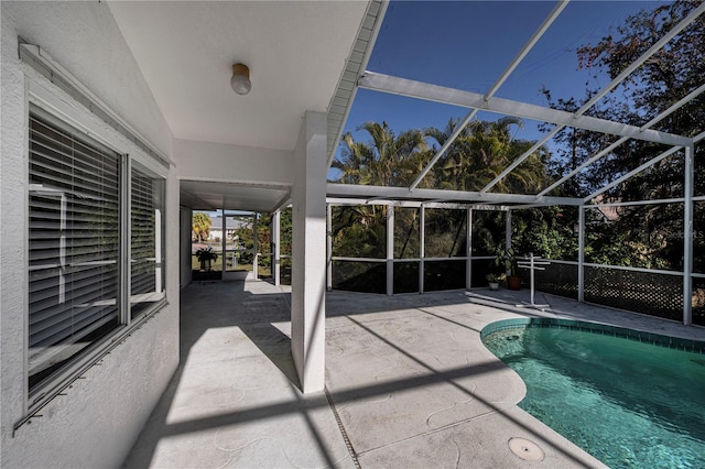 view of swimming pool with glass enclosure and a patio area