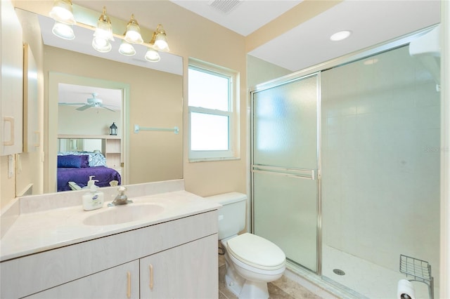 bathroom with ceiling fan, toilet, a shower with shower door, and vanity