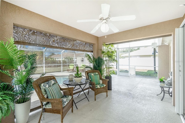 sunroom featuring ceiling fan, a healthy amount of sunlight, and decorative columns