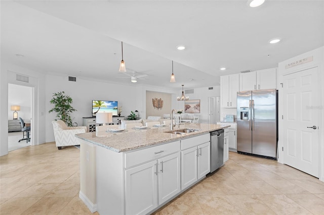 kitchen with white cabinetry, sink, decorative light fixtures, a kitchen island with sink, and appliances with stainless steel finishes