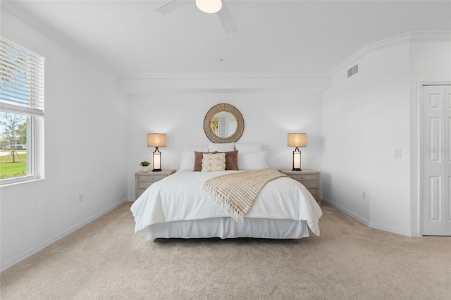 bedroom featuring ceiling fan, crown molding, and light colored carpet