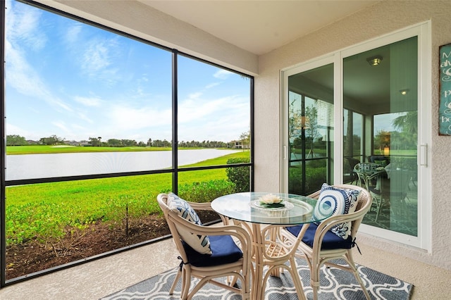 sunroom featuring a water view