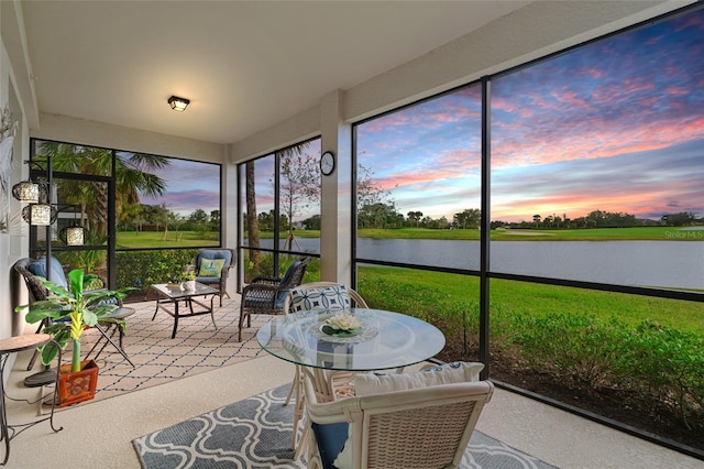 sunroom featuring a water view