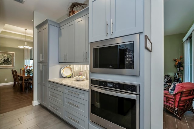 kitchen featuring light stone counters, appliances with stainless steel finishes, and light hardwood / wood-style flooring