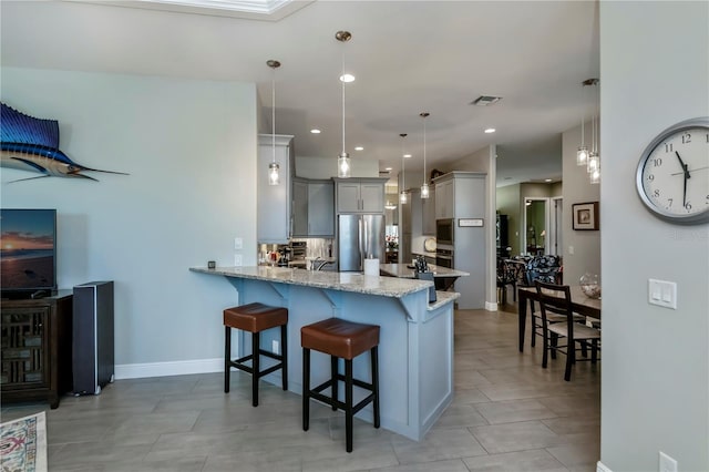 kitchen with kitchen peninsula, a kitchen breakfast bar, stainless steel appliances, gray cabinets, and hanging light fixtures