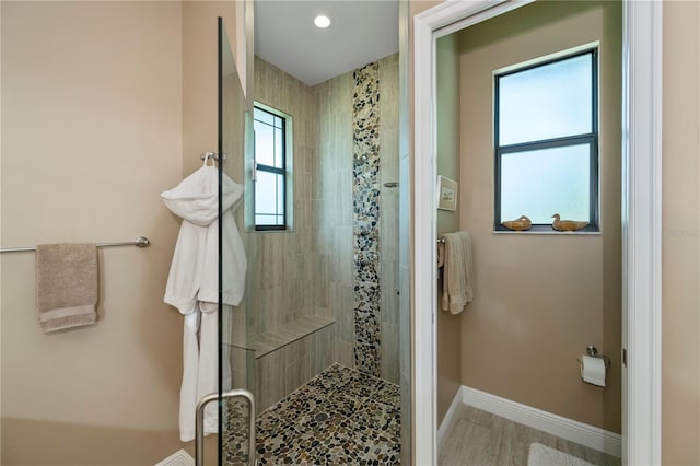 bathroom with hardwood / wood-style floors, an enclosed shower, and a wealth of natural light