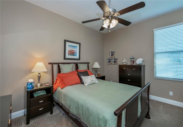 carpeted bedroom featuring ceiling fan and multiple windows