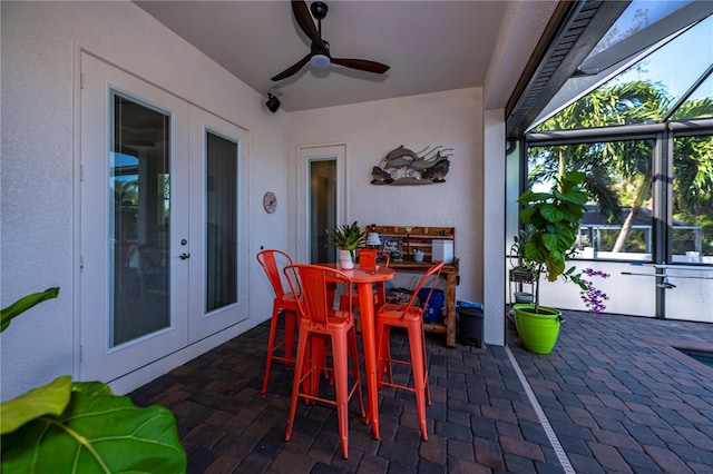 view of patio / terrace featuring french doors, ceiling fan, and a lanai