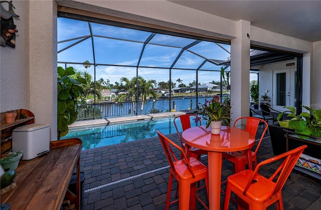 view of swimming pool featuring a lanai, a water view, and a patio