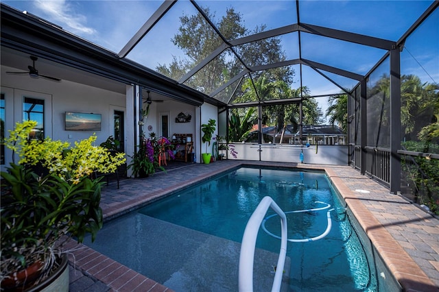 view of swimming pool featuring ceiling fan, a lanai, and a patio