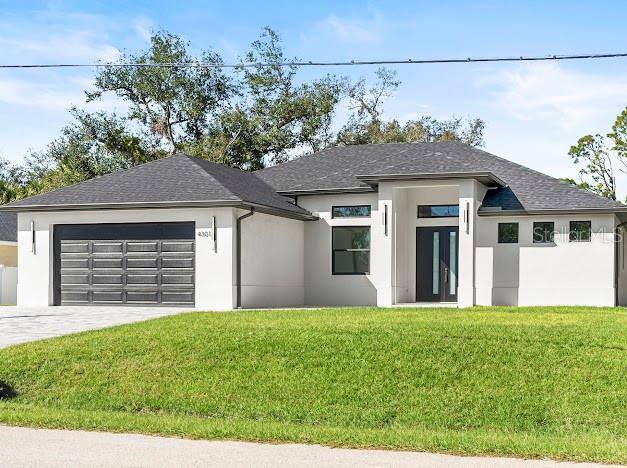 view of front of house with a garage and a front lawn