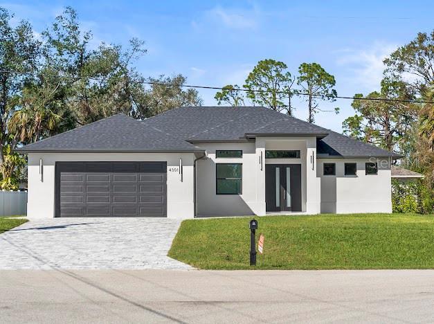 view of front of house featuring a garage and a front lawn