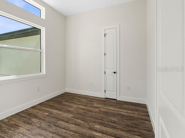 unfurnished room with dark hardwood / wood-style flooring