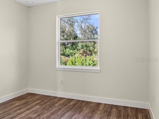 empty room with dark hardwood / wood-style floors