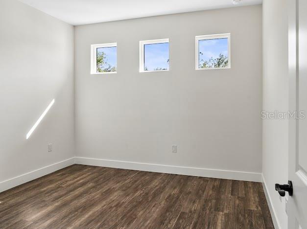 spare room with dark hardwood / wood-style flooring