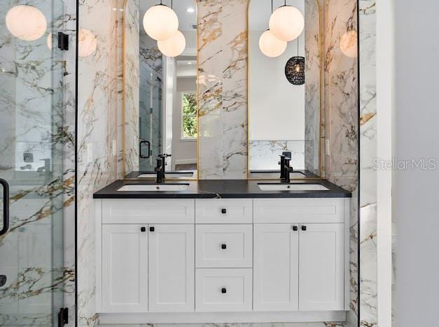 4301 Marcella Ter, North Port, FL 34286 - bathroom featuring a marble finish shower and double vanity
