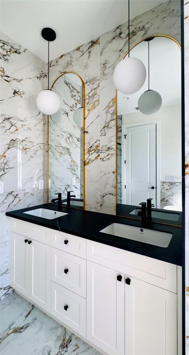 bathroom with vanity and tile walls