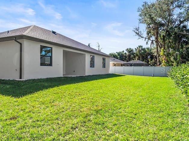 rear view of property featuring a lawn