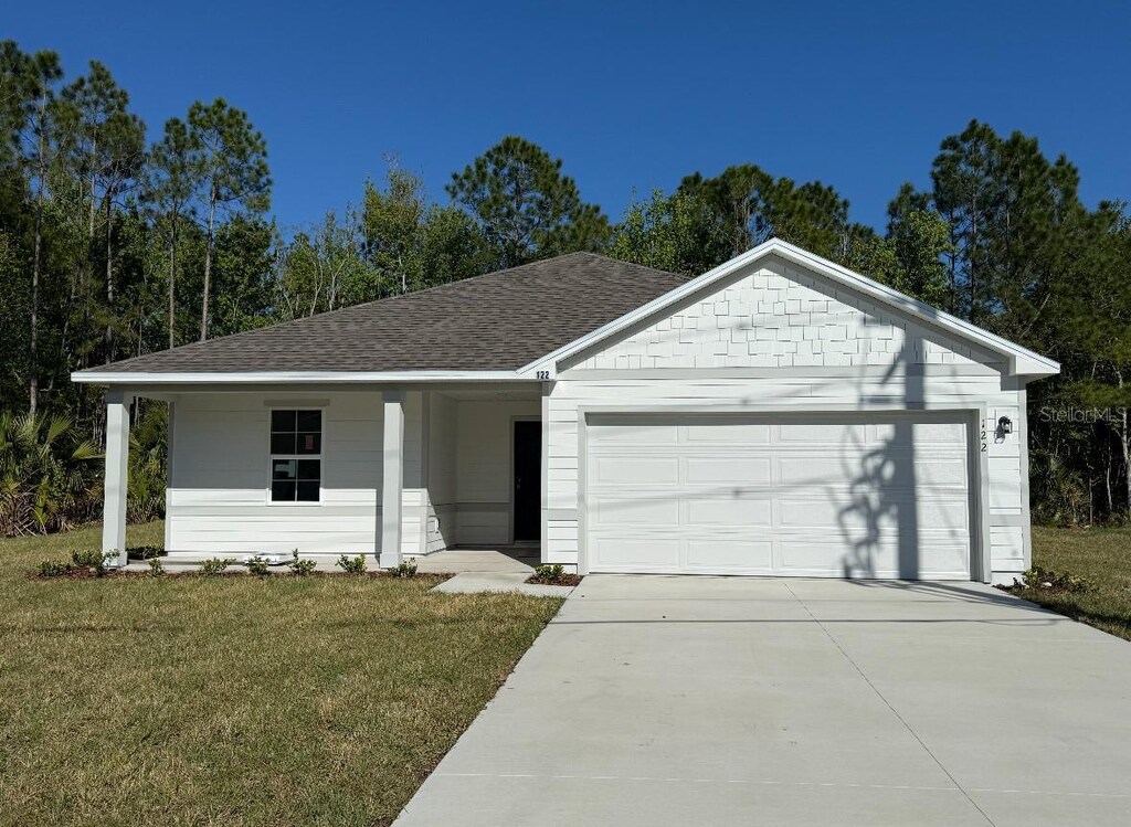 122 Bird Of Paradise Dr, Palm Coast, FL 32137 - ranch-style house with a garage, roof with shingles, driveway, and a front lawn