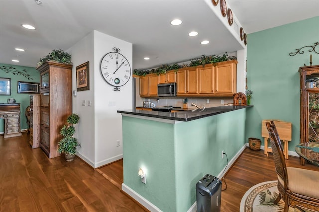 kitchen with kitchen peninsula and dark wood-type flooring