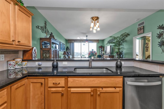 kitchen featuring dishwasher, dark stone countertops, and sink