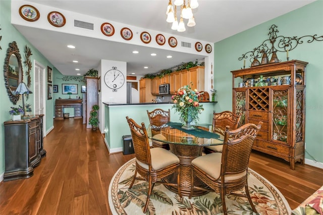 dining room featuring dark hardwood / wood-style flooring and an inviting chandelier