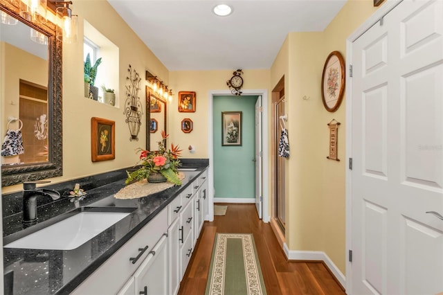 bathroom featuring wood-type flooring, vanity, and walk in shower