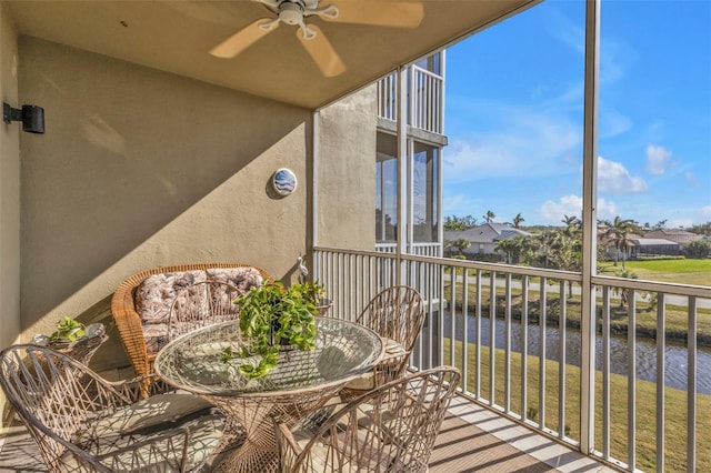 balcony with ceiling fan and a water view