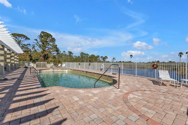 view of swimming pool with a patio area and a water view