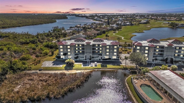 aerial view at dusk featuring a water view