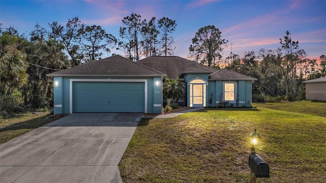 ranch-style house featuring a garage and a lawn