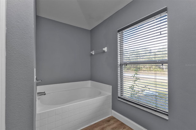 bathroom featuring hardwood / wood-style flooring and a bath