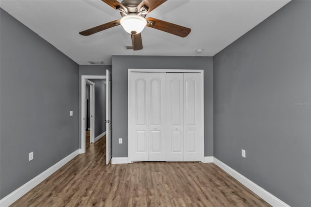 unfurnished bedroom with hardwood / wood-style flooring, ceiling fan, and a closet