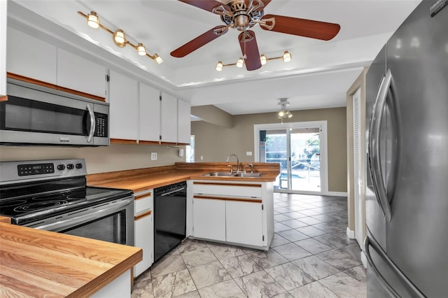 kitchen with kitchen peninsula, white cabinetry, sink, and appliances with stainless steel finishes