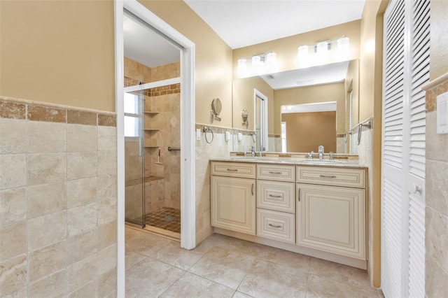 bathroom featuring tile patterned flooring, vanity, an enclosed shower, and tile walls