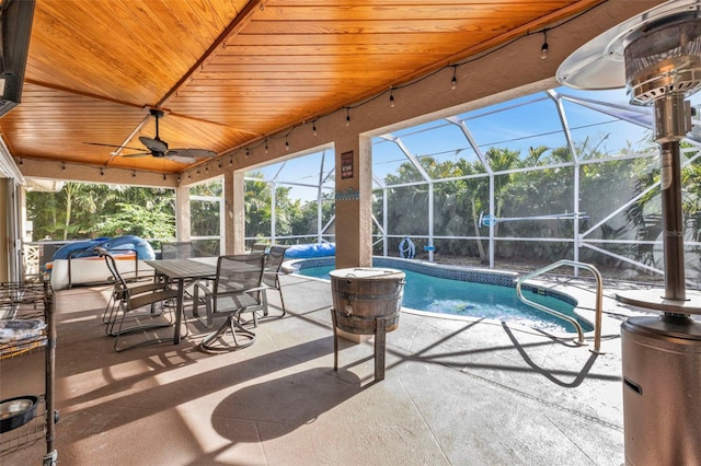 view of pool with ceiling fan, a lanai, and a patio